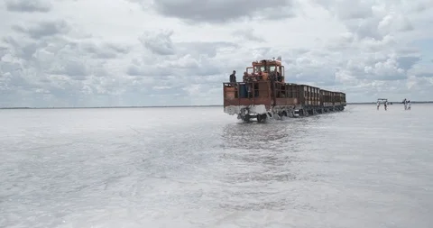 Old steam-powered train moves along sunken rail, train works on salt production Stock Footage 118301894