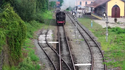 Old steam train and antique carriages run on the tracks between rice fields Stock Footage 67456005