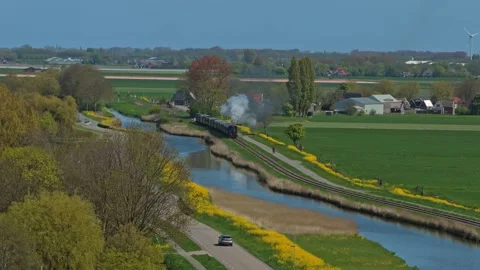 Old steam train traveling through dutch countryside landscape Stock Footage 341523898