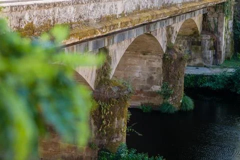 Old stone arch bridge spanning tranquil river Foto stock