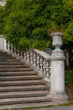 Old stone balustrade of railing background of green trees. Classic design and Stock Photos