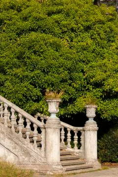 Old stone balustrade of railing background of green trees. Classic design and Stock Photos