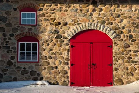 Old stone barn with bright red door Stock Photos