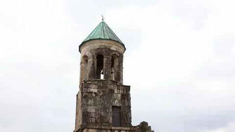 Old stone bell tower with green roof and cross Stock Footage 331200836