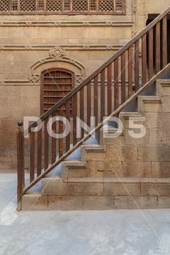 Old stone bricks wall and, window and staircase with wooden balustrade Stock Photos