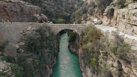 Old stone bridge and a river drone view. Cloudy summer weather and great valley Stock Footage 248461638