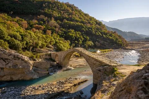 Old stone bridge with arch shape photographed during sunset. photo taken in Stock Photos