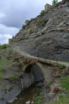 Old stone bridge on a mountain path Stock Photos
