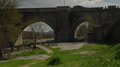 Old stone bridge with multiple arches spanning a dry riverbed Stock Footage 335461221