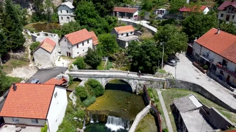 Old stone bridge over the river in the city. Aerial drone view of houses Stock Footage 157756136