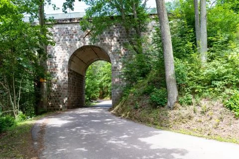 An old stone bridge over a small river. Railway crossing across the river in  Stock Photos