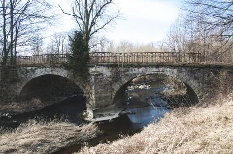 The old stone bridge with two arcs Stock Photos