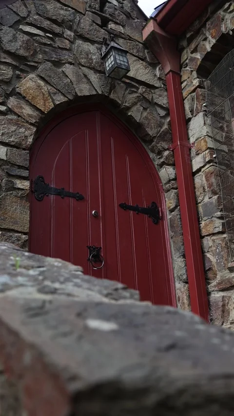 Old stone building with an antique red wooden door Stock Footage 341907024