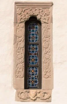 Old, stone carved windows frame with stained glass motif Stock Photos