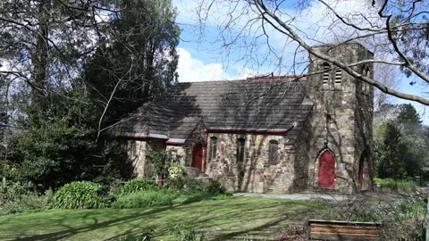 Old stone church with bell tower surrounded by trees and nature Stock Footage 341908198