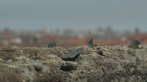 Old stone fence with sharp crashed bottles on the top and city district Stock Footage 94734511