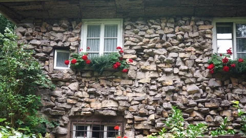 Old stone house with flowers in front of the windows Stock Footage 118228829