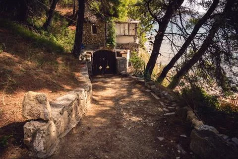 Old stone house hidden in pine forest near sea coast in Greece Stock Photos