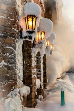 Old stone house with lanterns in snowy winter Stock Photos