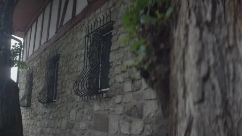 Old Stone House with Wrought Iron Window Grille, Rainy Facade, Static Shot Stock Footage 341424375