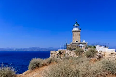 Old stone lighthouse on the high cape Malagavi, Loutraki, Greece. Stock-Fotos