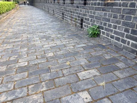 Old Stone Pathway Along Historic Brick Wall Stock-Fotos