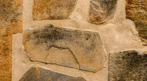 Old stone placed in the wall, interesting and original background Stock Photos