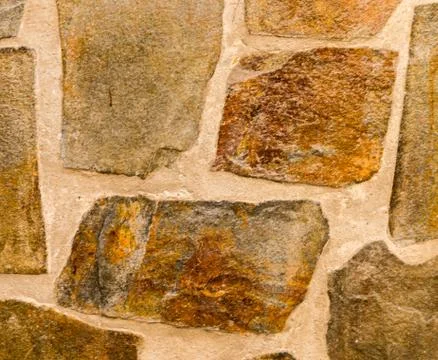 Old stone placed in the wall, interesting and original background Stock Photos