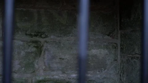 Old stone prison cell through view of metal bars Stock Footage 147279008