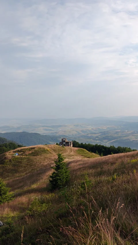 Old stone ruins on mountain peak overlooking a vast scenic valley Stock Footage 340577425