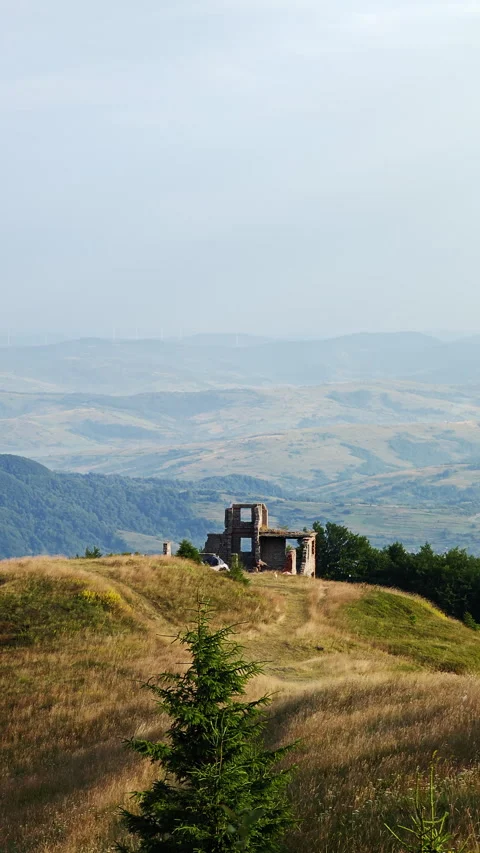 Old stone ruins on mountain peak overlooking a vast scenic valley Stock Footage 340577428
