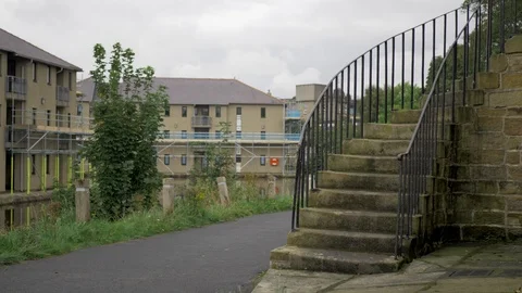 Old stone steps next to a canal with new building work Video stock 117432671