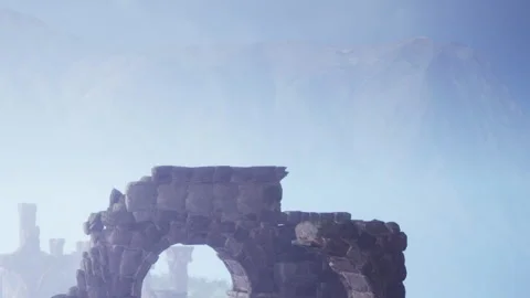 Old stone structure stands tall in a misty landscape with mountains Stock Footage 344098661