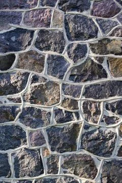 Old stone vertical wall rustic texture background Stock Photos