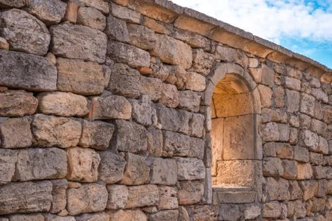 Old stone wall with arched window opening Photos