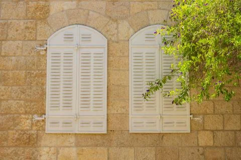 Old stone wall background building exterior facade with two arch shape window Foto stock