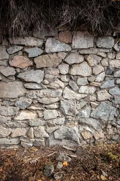 Old stone wall background with dry grass, vertical background Stock Photos