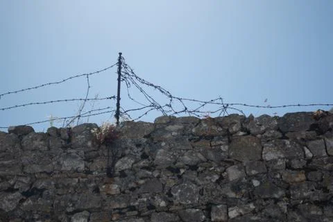 Old stone wall with barbed wire Foto stock