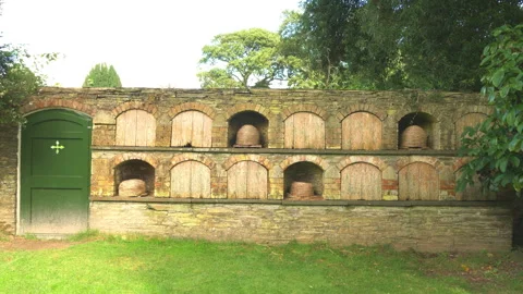 An old stone wall bee bole with recessed alcoves and wicker skeps. Stock Footage 288098153
