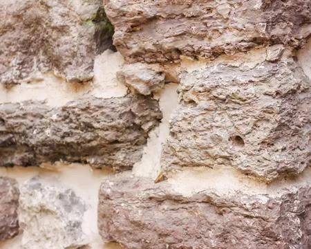 An old stone wall built from irregular blocks features visible weathering and Stock Photos