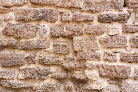 An old stone wall built from irregular blocks features visible weathering and Stock Photos