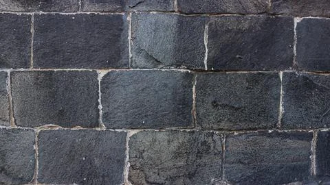 Old stone wall close up in soft beige palette. Stone tile background with d.. Stock Photos
