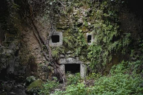 Old stone wall forming human face with pareidolia Stock Photos