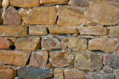 Old stone wall made of rough, irregularly shaped rocks showcasing rustic te.. Stock Photos