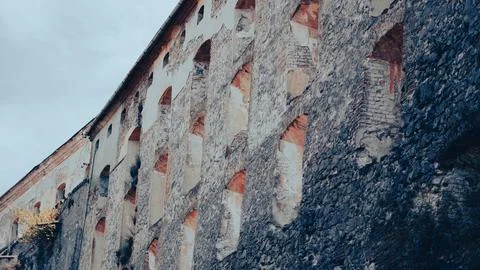 Old stone wall of a medieval castle with weathered surface and textures Stock Photos