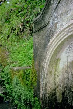Old stone wall with moss and greenery on hillside background Stock Photos