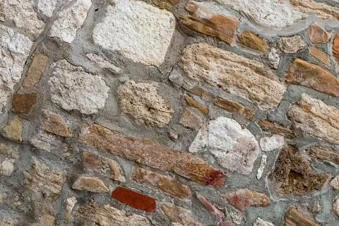 Old stone wall rectangular square cobblestones beige brown in cement-base bac Foto stock