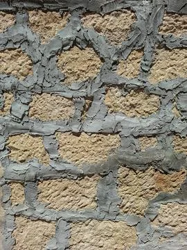 Old stone wall with rough texture and grey mortar under bright sunlight Fotos de archivo
