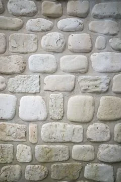 Old stone wall with rounded limestone cobble background Stock Photos
