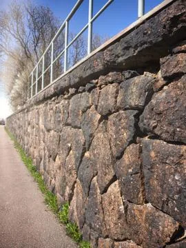 Old stone wall with sunlight on the end Stock Photos